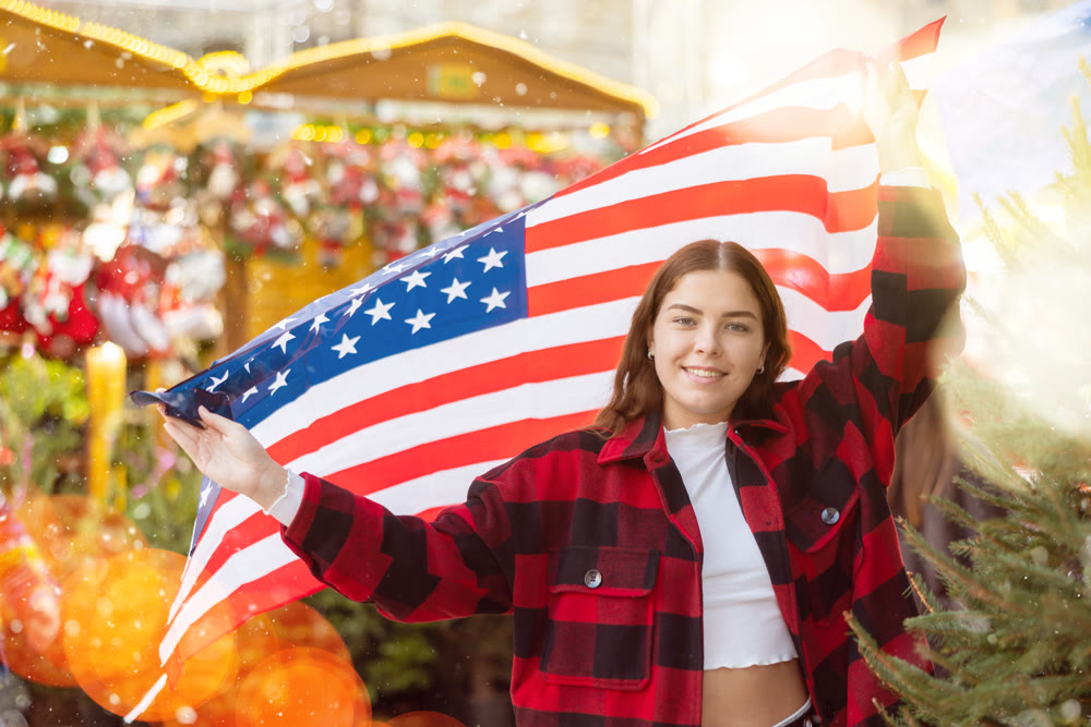 Woman waving USA flag at street new year fair