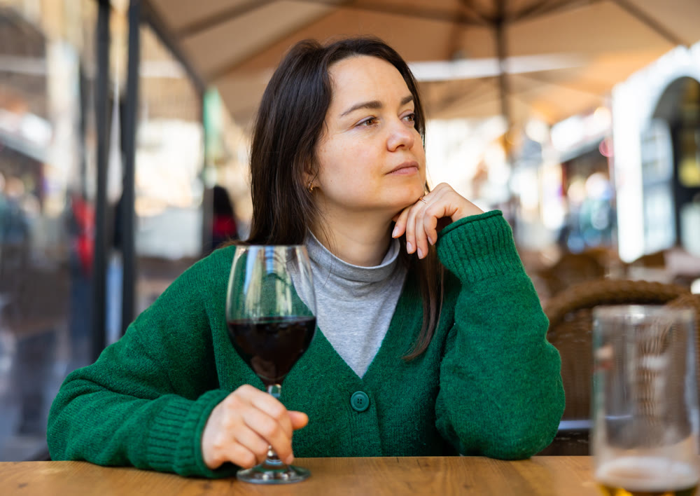 Portrait of thoughtful woman drinking red wine in diner