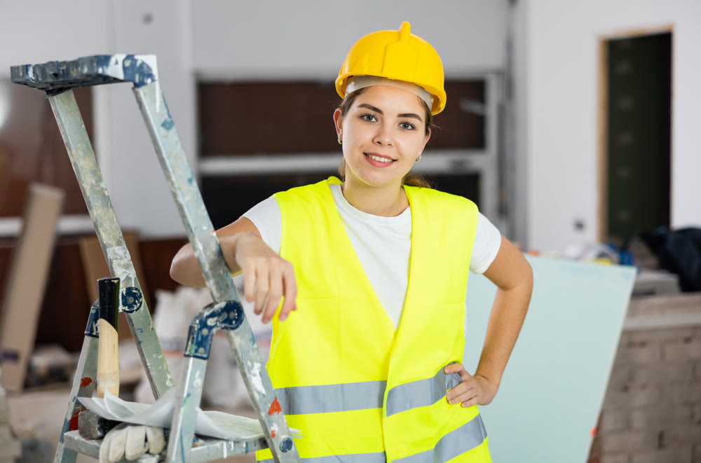 Smiling young female civil engineer standing at construction site