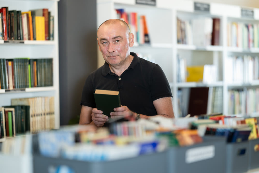 Adult man choosing book in bookstore