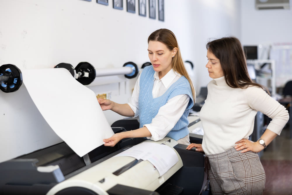 Team of professionals works on printing equipment in print shop