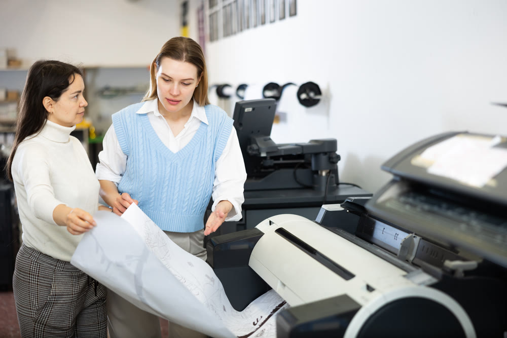 Portrait of team of professionals works on printing equipment