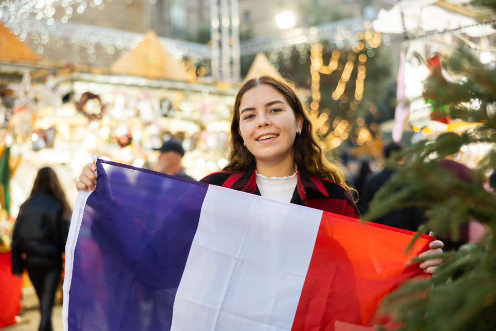 Woman waving France flag at street new year fair