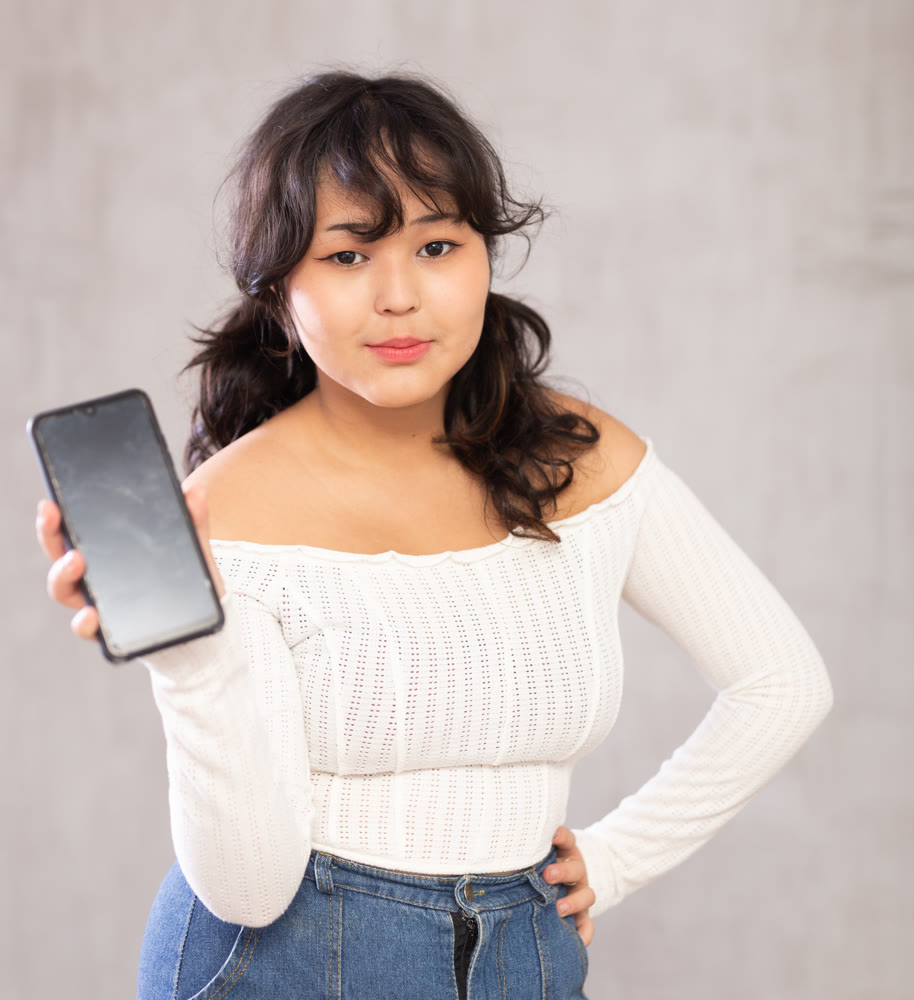 Smiling young girl holding mobile phone