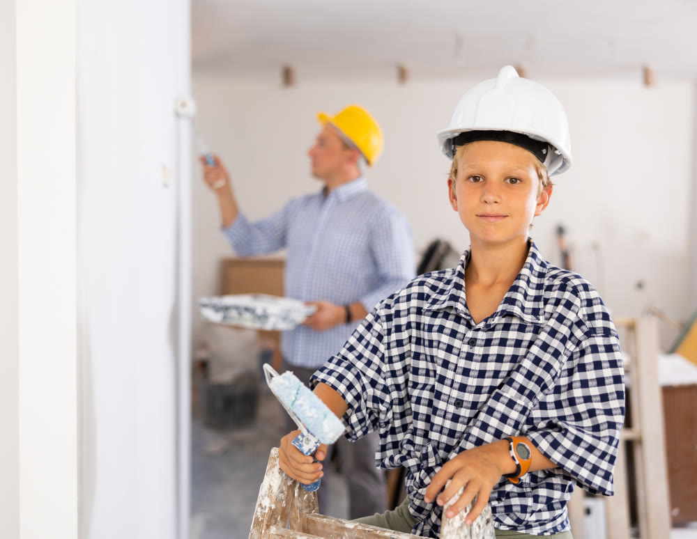 Portrait of positive young boy with paint roller