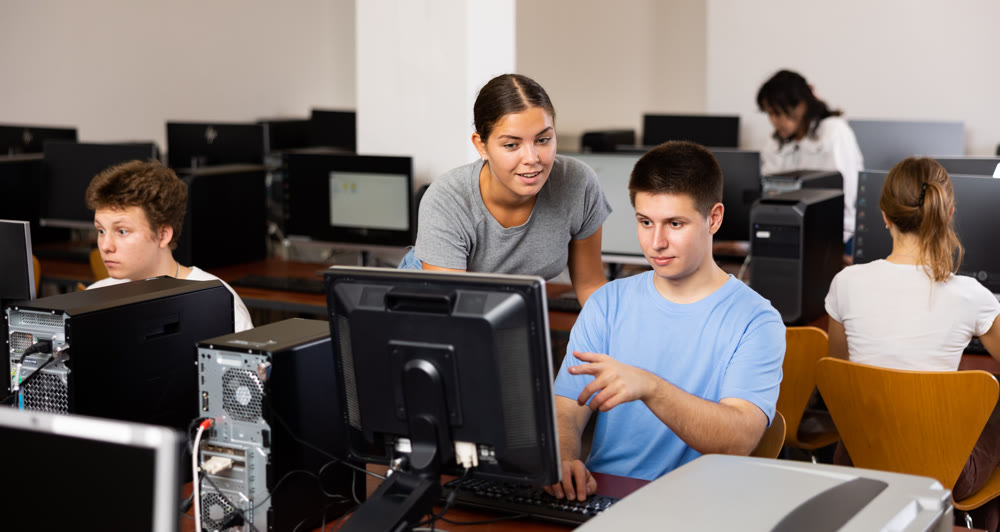 Teacher and teenage boy studying computer science