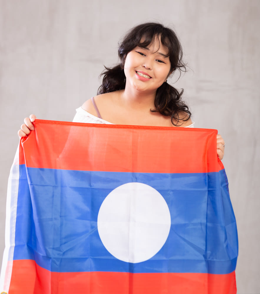 Smiling young girl holding Laos flag