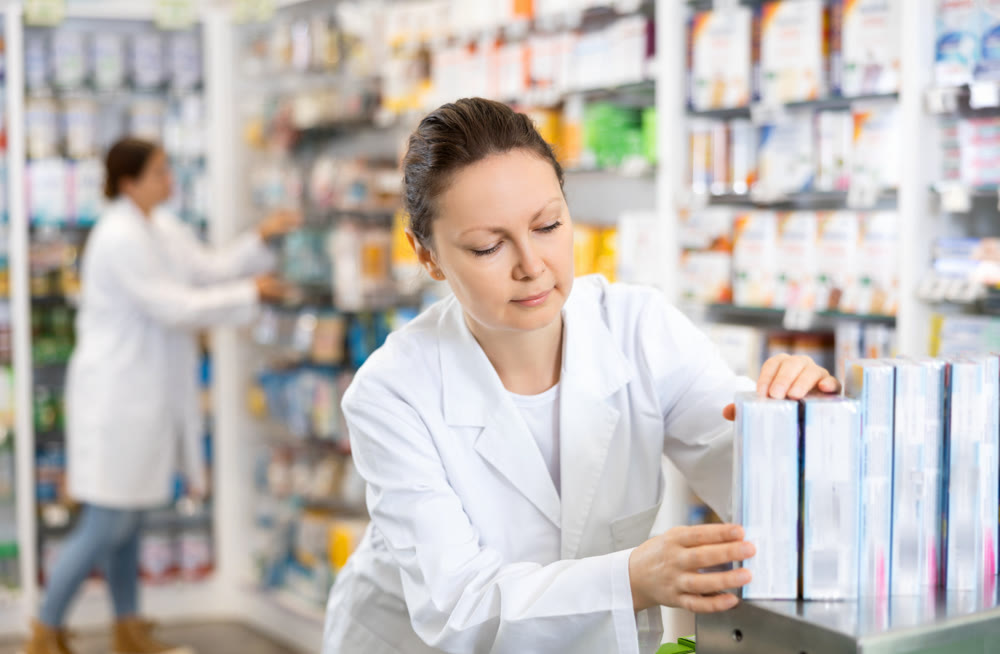 Pharmacy employee puts new healing body cosmetics on shelves