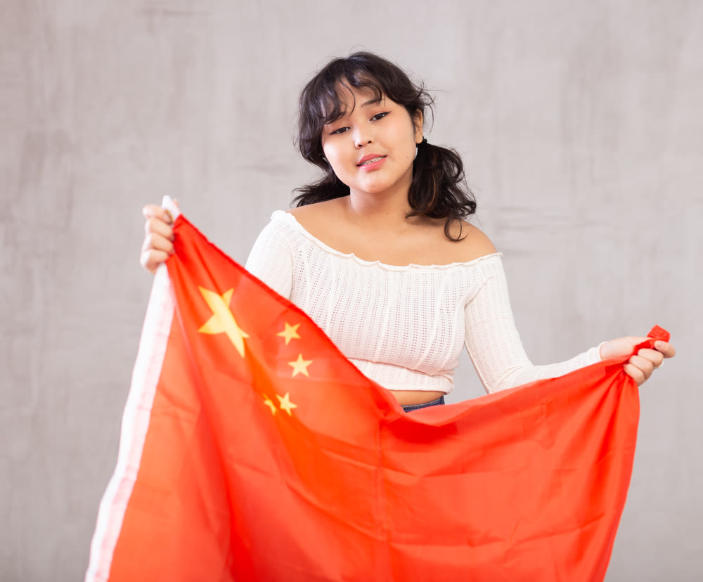 Smiling young girl holding China flag