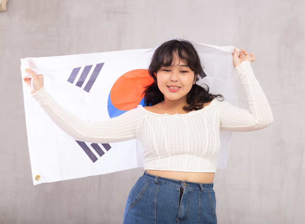 Smiling young girl holding South Korea flag