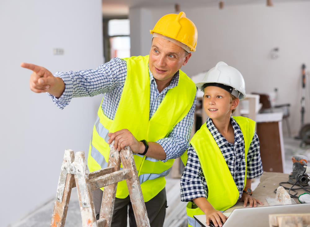 Young boy and his father discussing work plan in new apartment