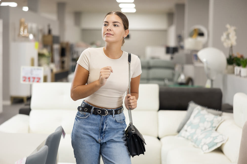 Girls eyes scan room furniture store, searching for perfect item to complete living space