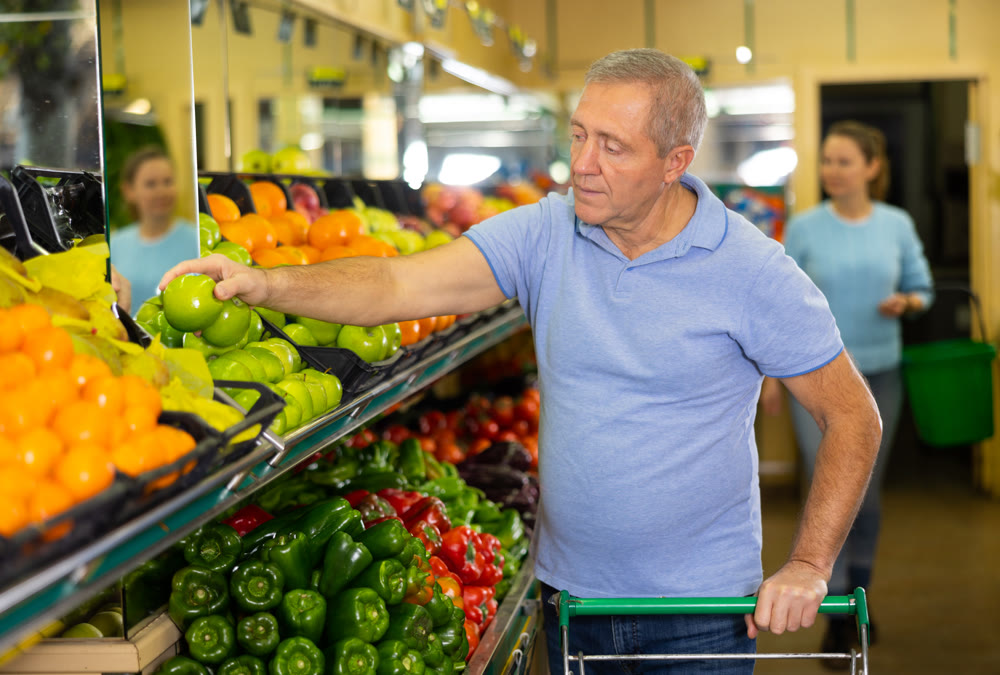 man buys apples in supermarket