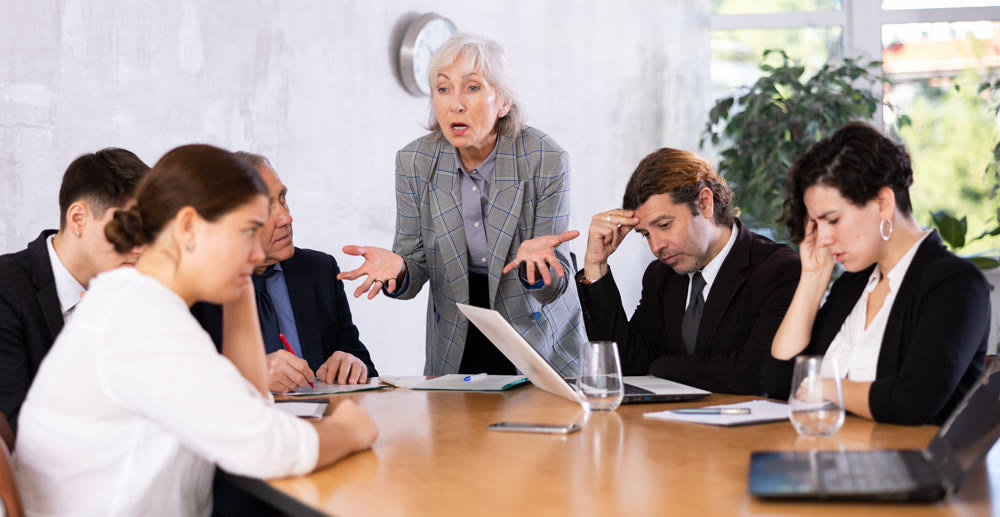 Elderly female boss expresses dissatisfaction with the work of top managers team