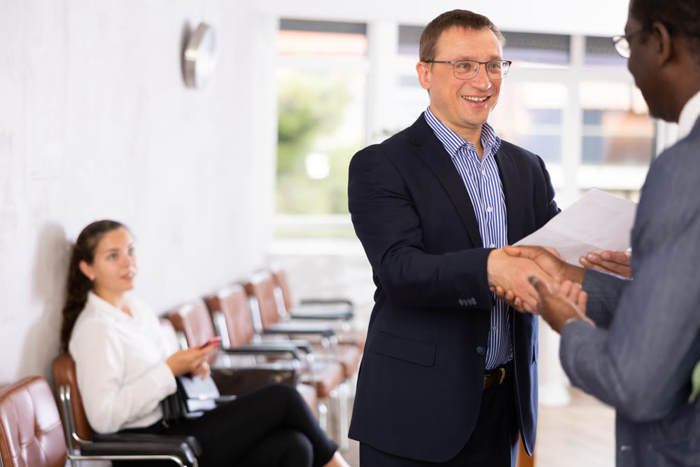 Two adult man shaking hands in reception