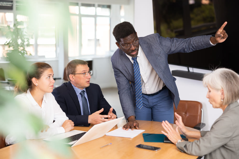 African man auditor speaks about trouble before meeting of frowning shareholders of businessmen