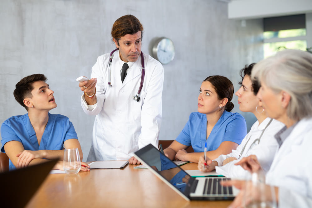 Doctor switching slides of presentation during medical consultation with colleagues