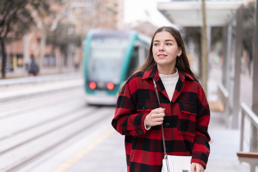Woman standing at a tram stop