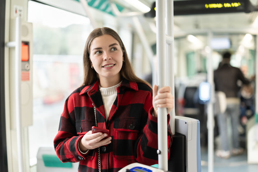 Girl with long hair standing in tram with phone
