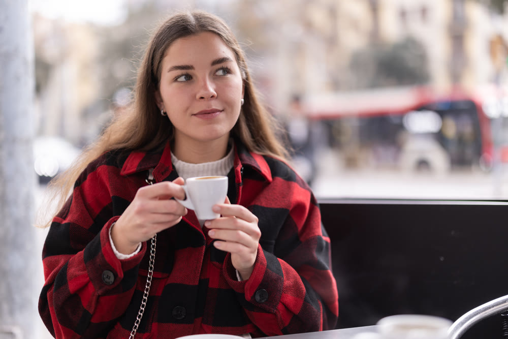 Girl in a street cafe with a cup of hot coffee
