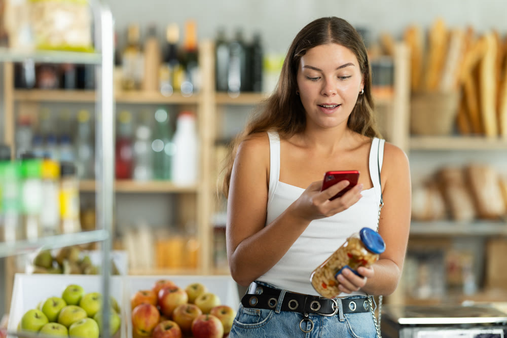 Young woman scanning qr code of beans