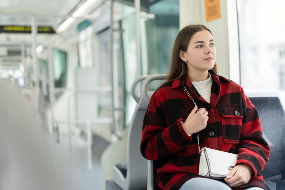 Young woman sitting in tram and looking away