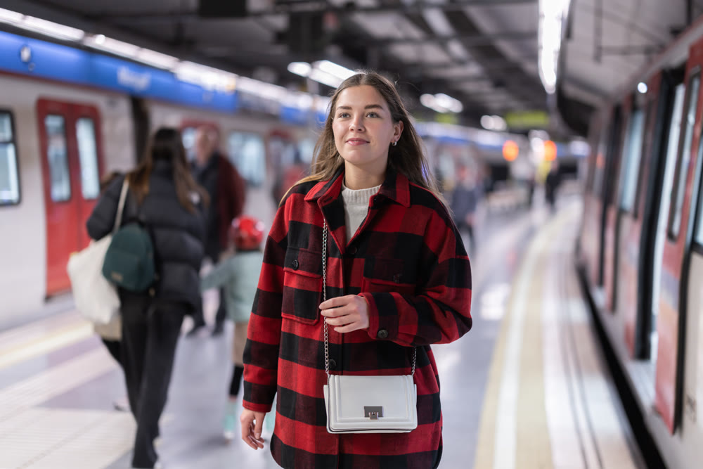 Girl is standing on subway platform, waiting for train to arrive