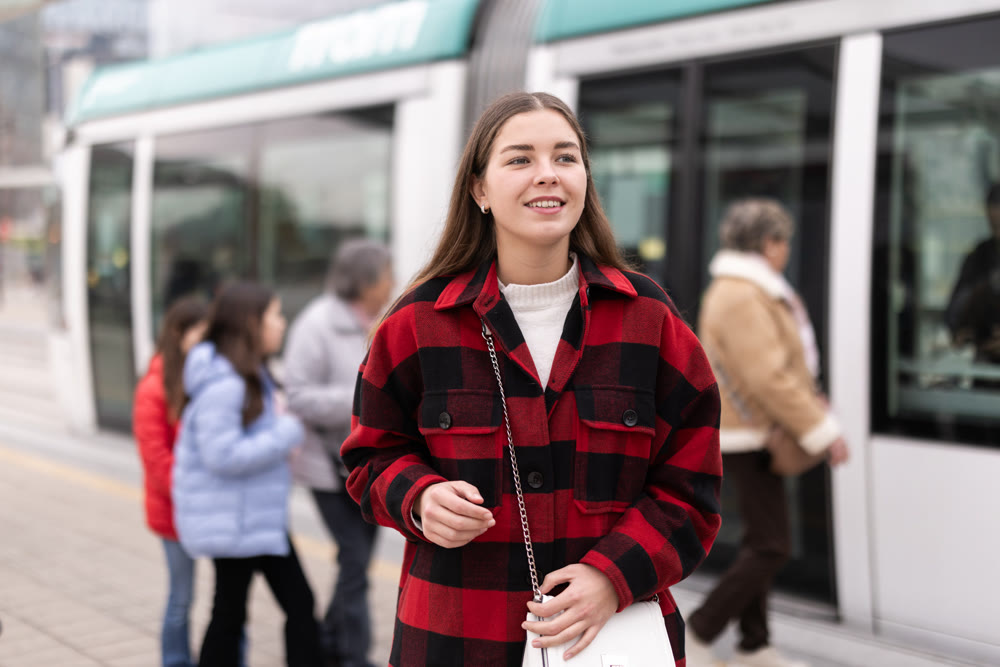 Woman standing at a tram stop