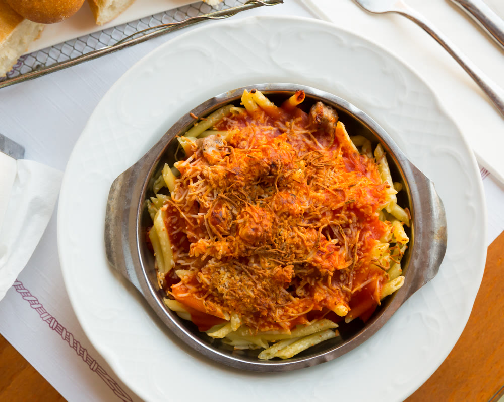 Top view of macaroni baked with sausage, tomato