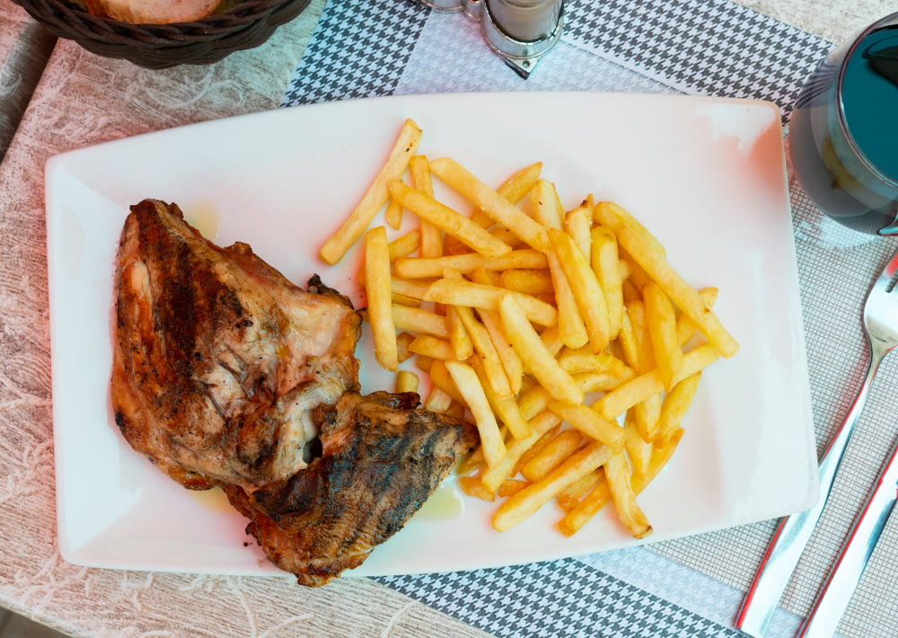 Closeup of homemade baked chicken legs with potatoes
