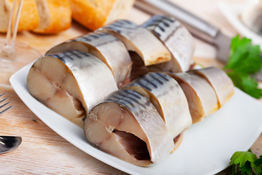 Slices of lightly salted mackerel with greens at plate