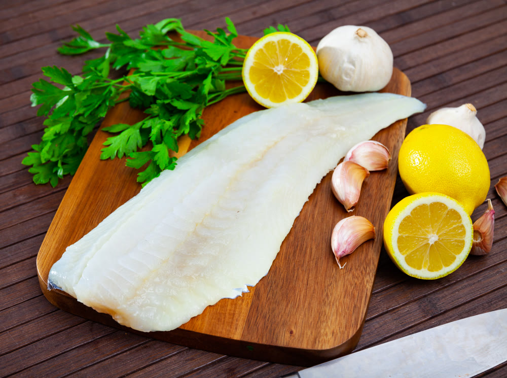Raw atlantic cod fillet on wooden table