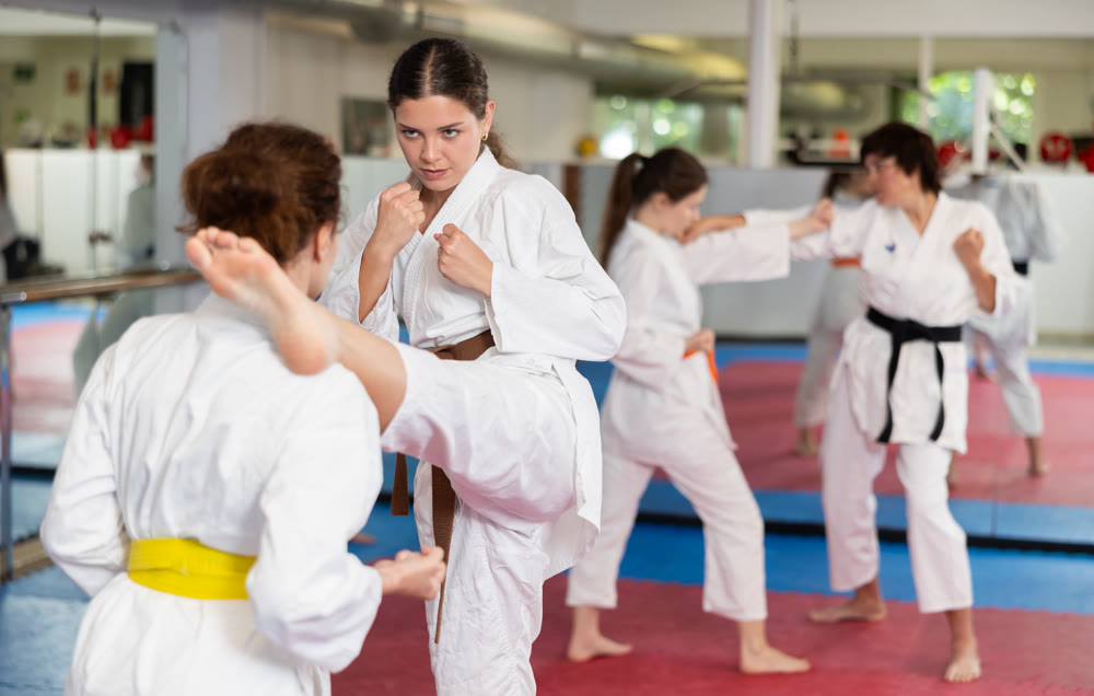Women pupils train to perform defensive karate installations and attacking combat techniques