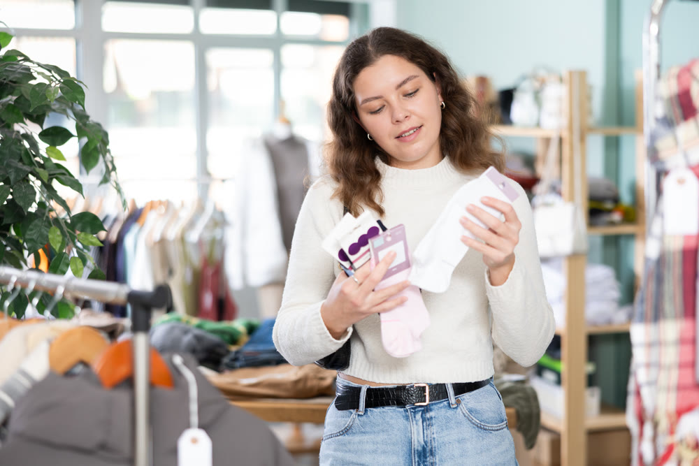 Young woman choosing a set of socks in a clothing store