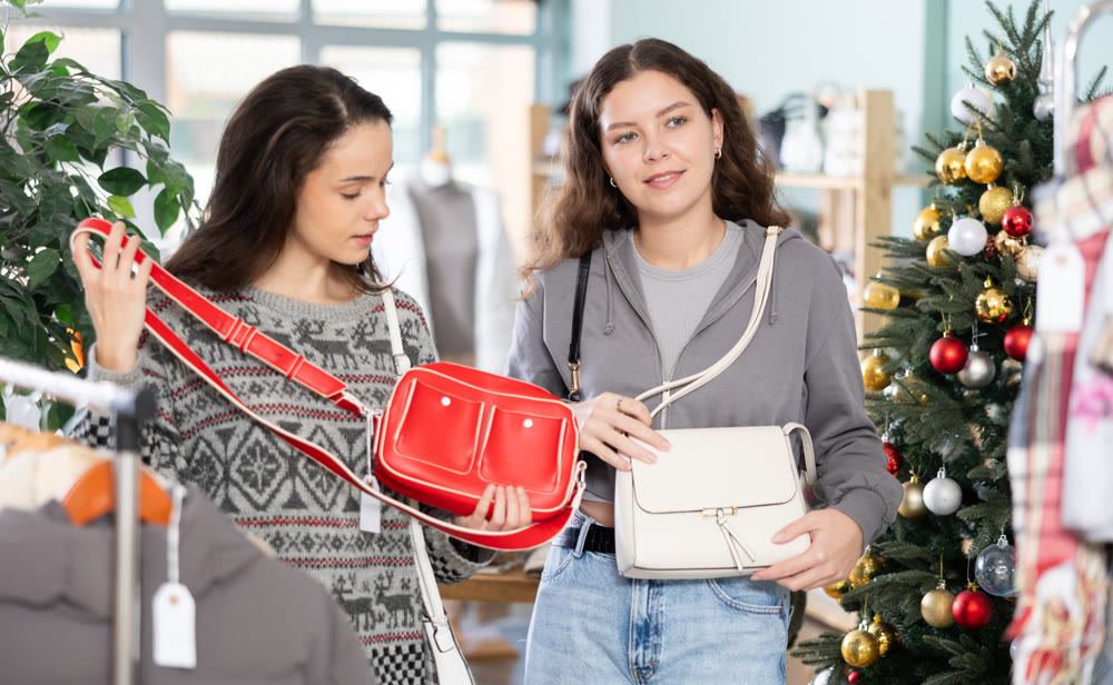 Two girls at trading floor pick out handbag, X mas shopping