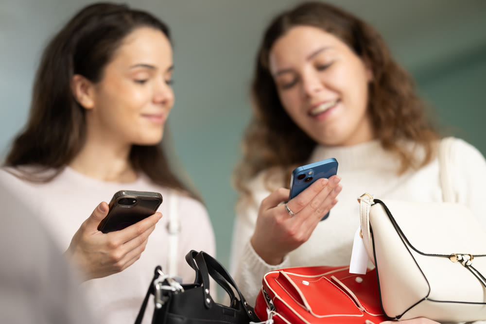 Two young women scanning qr code for handbag