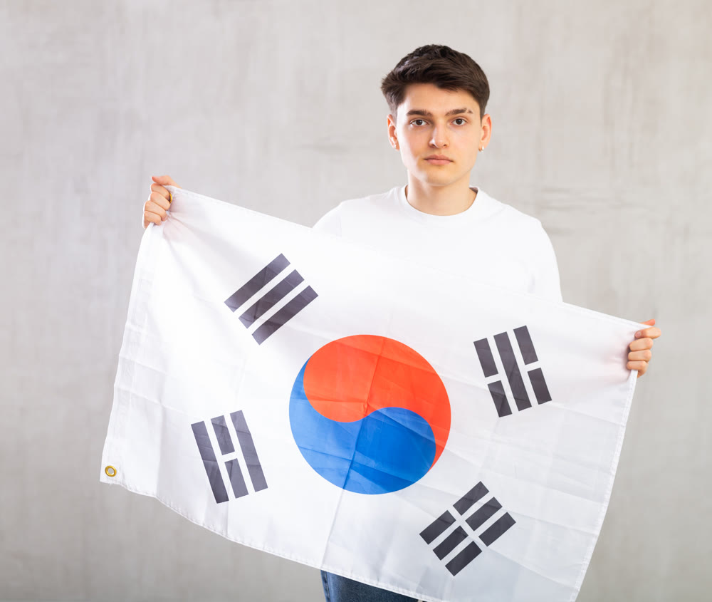 Male fan of favorite team of South Korea with the national flag in her hands