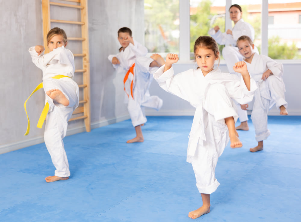Children in kimono standing in fight stance during group karate training