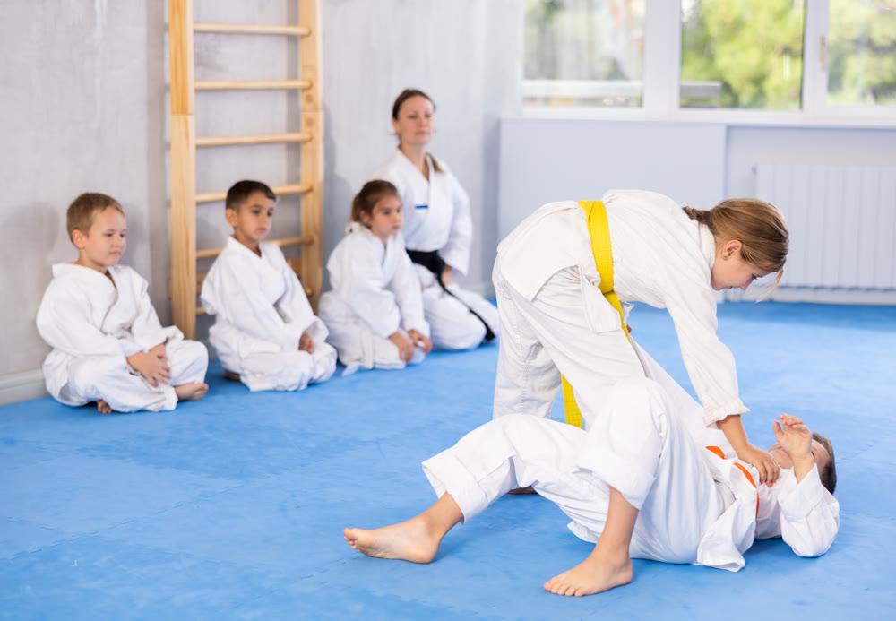 Children athletes in pair conduct training battle in oriental fighting technique
