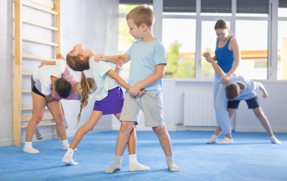 Boys and girls in gym perform basic elements of krav maga self-defense system.