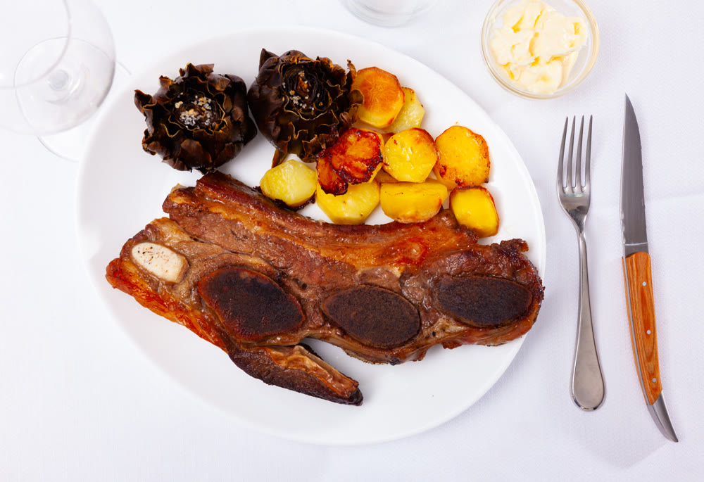 Portion of just cooked churrasco with potatoes and artichokes