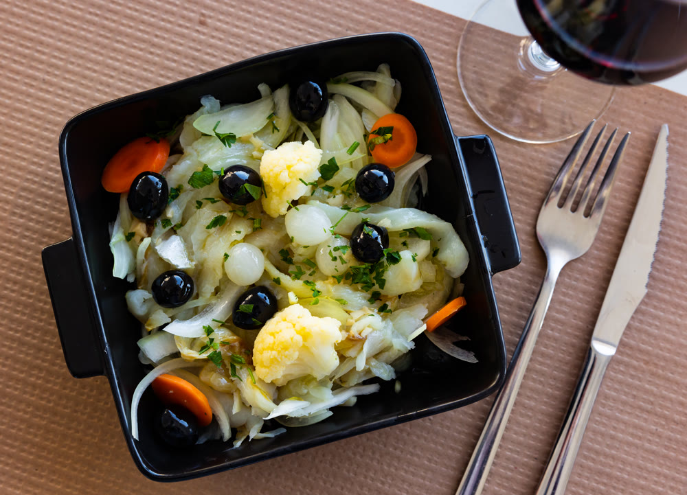 Salad of codfish with marinated onions, cauliflower, carrots and olives