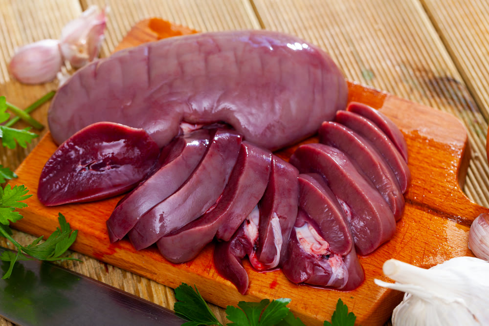 Raw pork kidneys on wooden table