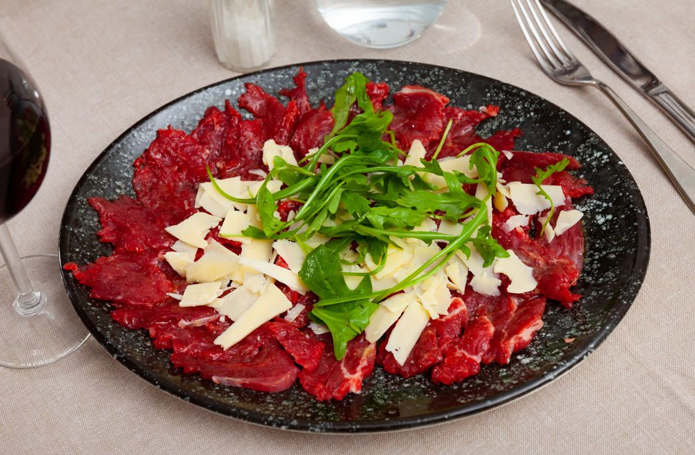 Beef carpaccio with grated hard cheese and arugula