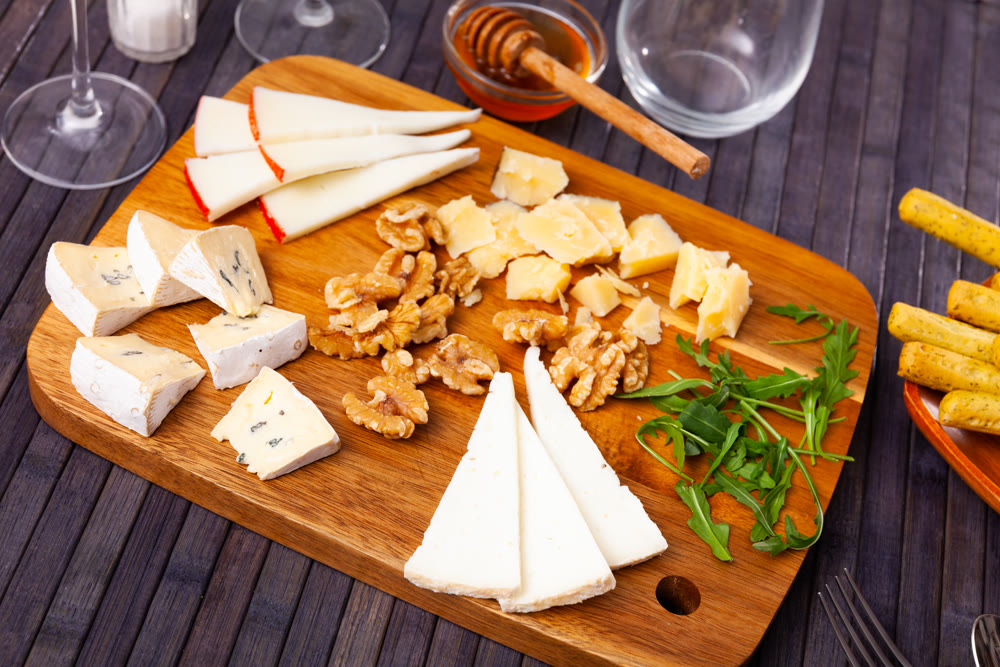 Various types of cheese on wooden board