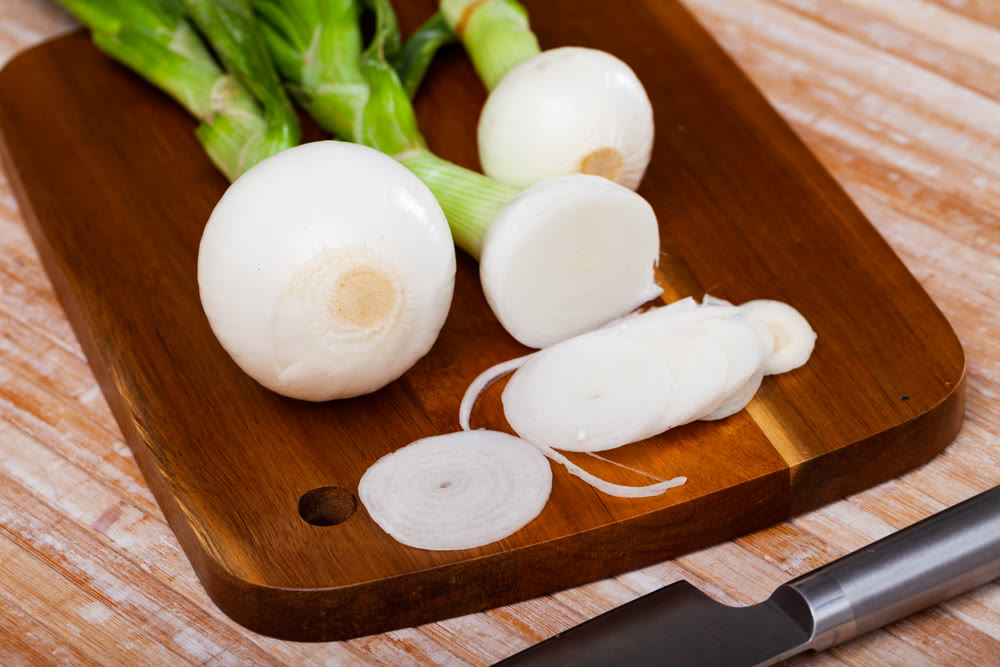 Spring onion on wooden table, food preparation