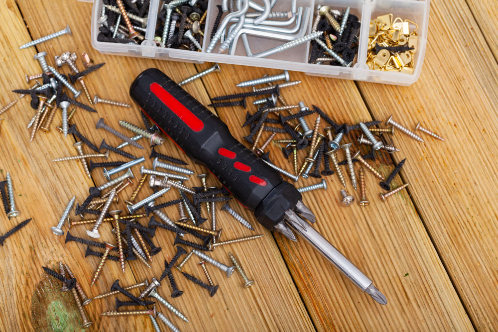 Screwdriver and screws on wooden table