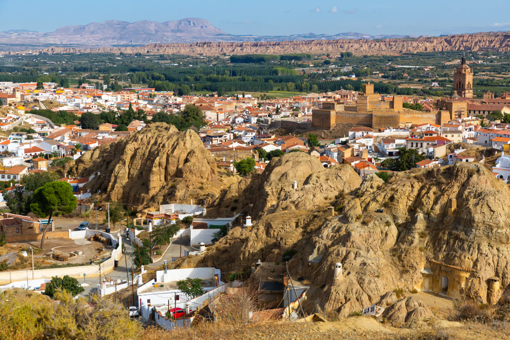 View from drone of cave house area and alcazaba in Guadix, Spain