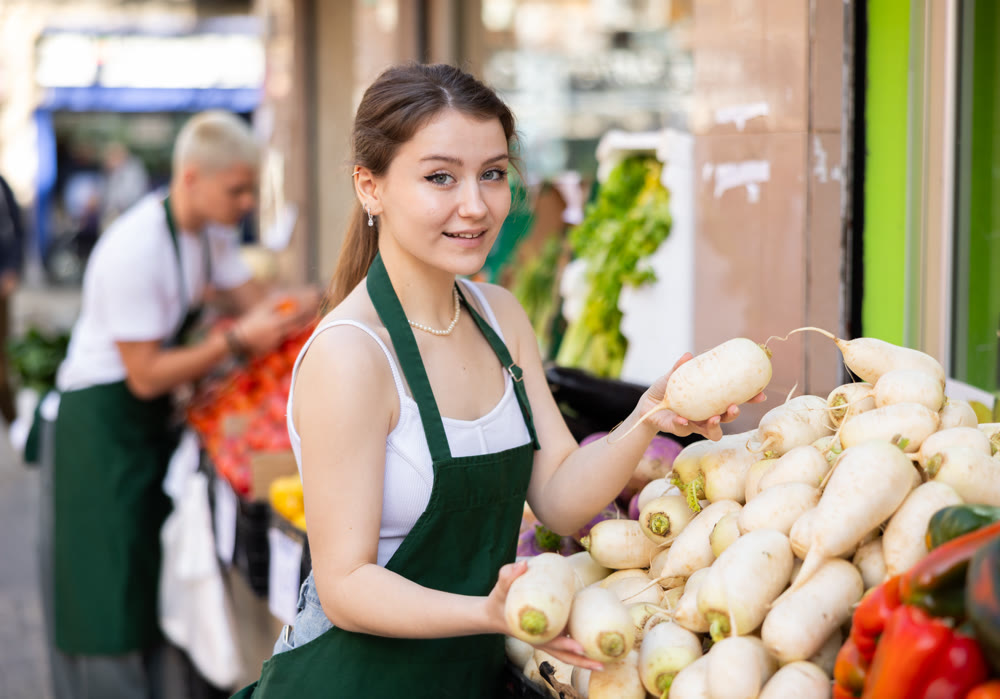 Female seller offering daikon