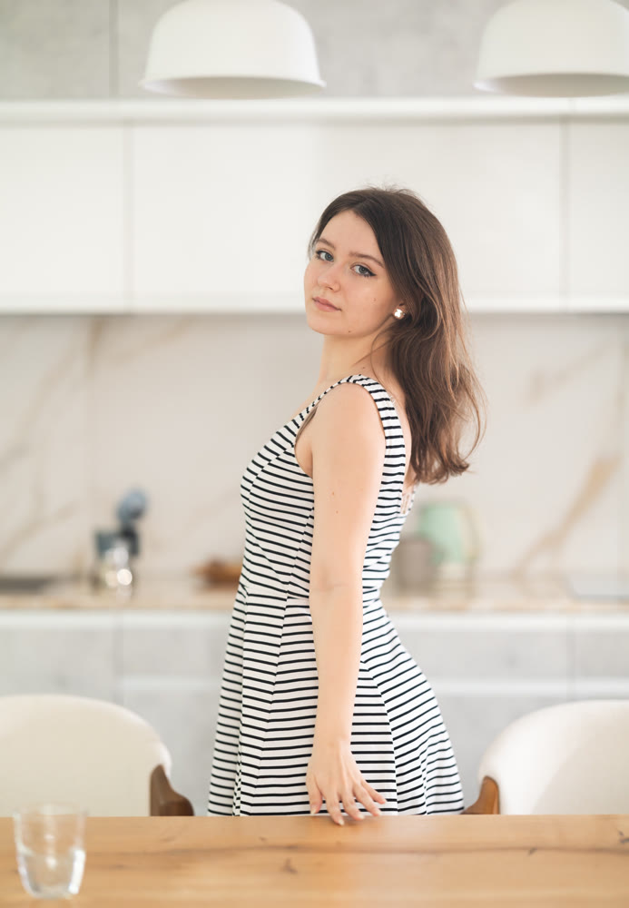Smiling young woman standing at table